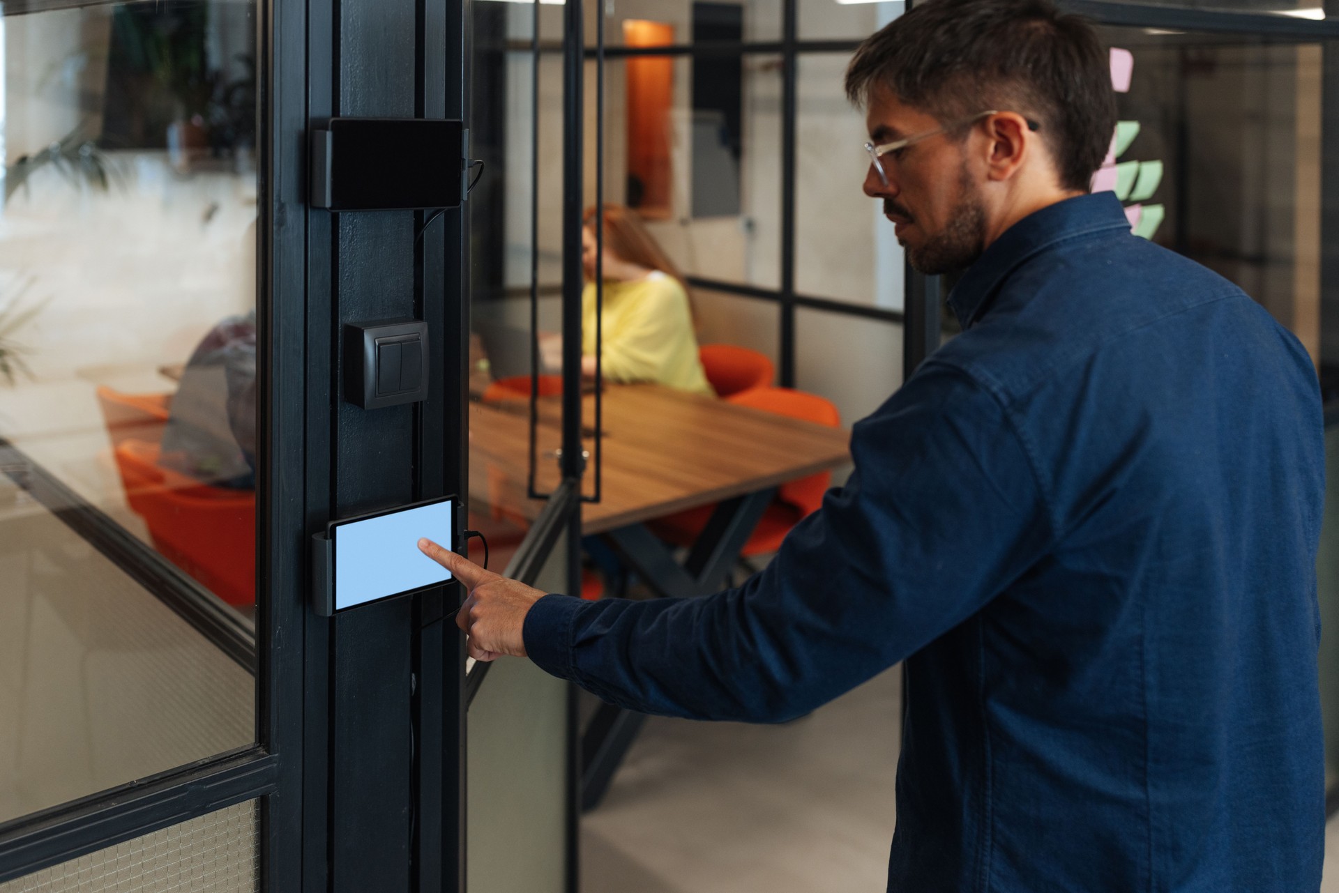 Office worker using touchscreen panel for access control in modern office